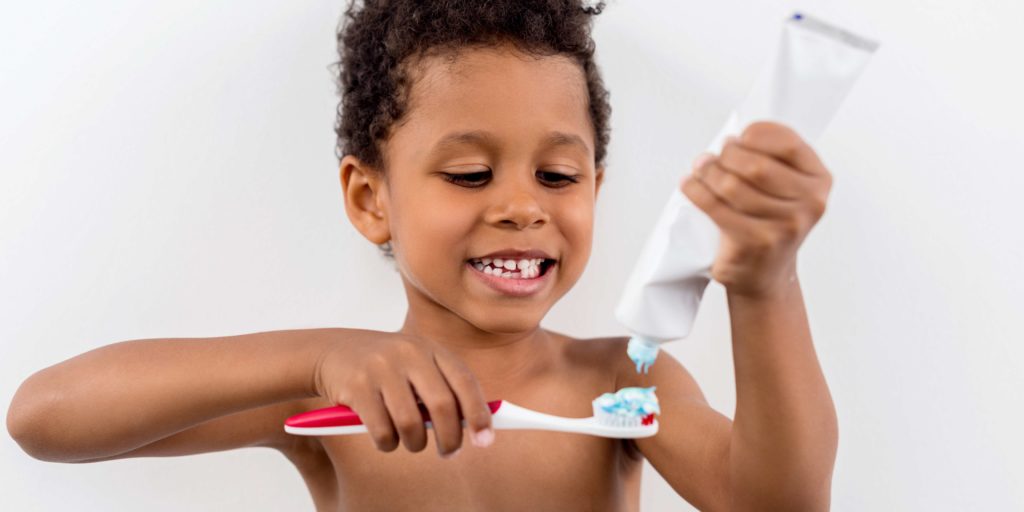 Niño echando pasta de dientes